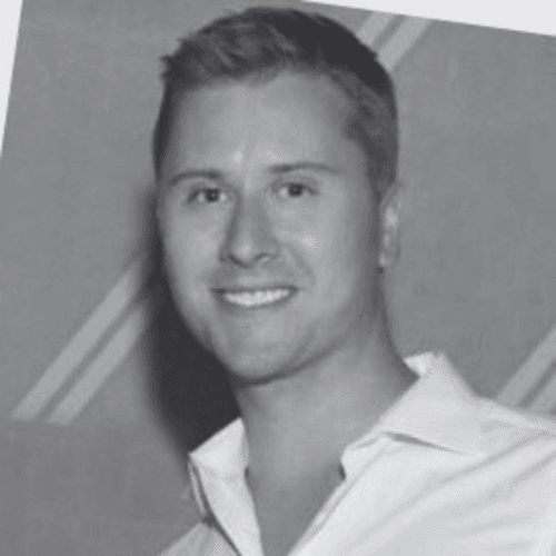 Black and white professional headshot of Joshua Aven, a SovDoc leadership team member, smiling and wearing a collared shirt.