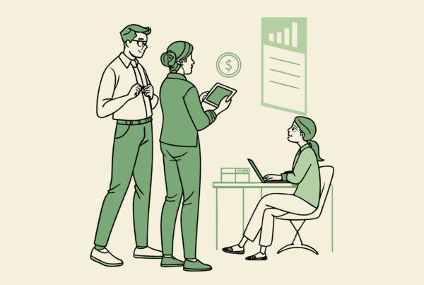 Financial planning professionals discussing primary care practice mergers and acquisitions, with one consultant analyzing financial data on a tablet while a medical facility appears in the background - SovDoc healthcare M&A advisory services for medical practice transactions.