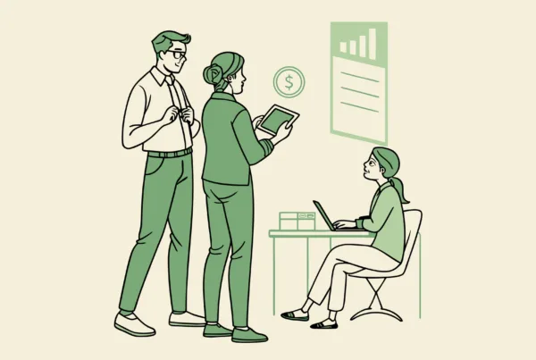 Financial planning professionals discussing primary care practice mergers and acquisitions, with one consultant analyzing financial data on a tablet while a medical facility appears in the background - SovDoc healthcare M&A advisory services for medical practice transactions.