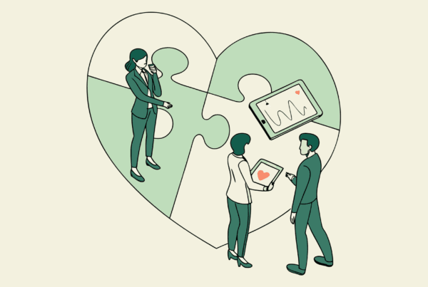 Healthcare consultants discussing cardiology practice mergers and acquisitions around a symbolic heart, representing SovDoc's specialized advisory services for medical practice M&A in the cardiovascular sector.