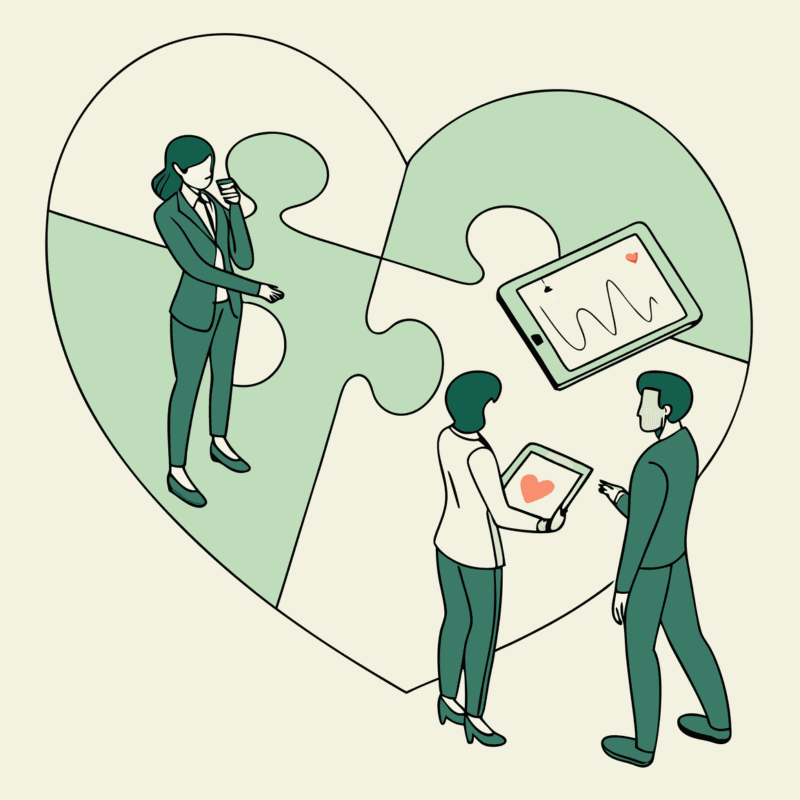 Healthcare consultants discussing cardiology practice mergers and acquisitions around a symbolic heart, representing SovDoc's specialized advisory services for medical practice M&A in the cardiovascular sector.