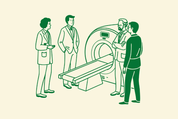 Business professionals gather around medical imaging equipment in a strategic discussion, representing SovDoc's expertise in radiology practice mergers and acquisitions and financing advisory services.