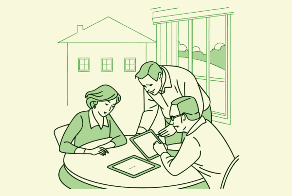 SovDoc healthcare M&A advisors discussing assisted living facility mergers and acquisitions strategy around a conference table, with ALF building visible in background - representing medical practice transaction advisory services.